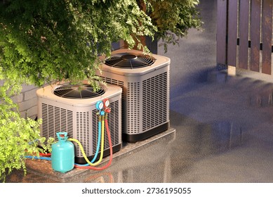 HVAC installation, Climate control services. Outdoor air conditioning units connected to refrigerant gauges and gas cylinder for cooling system maintenance and energy efficiency, 