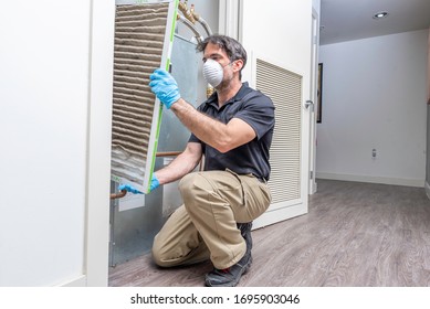 Hvac Maintenance Technician Removing A Diry Air Filter From A Heat Pump