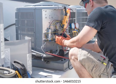 Hvac Repair Technician Using A Volt Meter To Test Components On An Air Conditioner Condenser. 