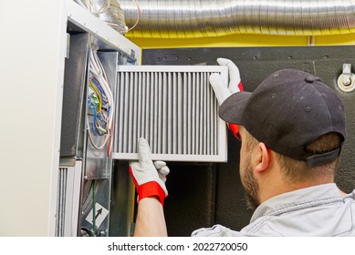 HVAC Service Technician Changing Dirty Air Filter In The Central Ventilation System. Change Filter In Rotary Heat Exchanger Recuperator. Air Duct Ventilation System Maintenance For Clean Air.