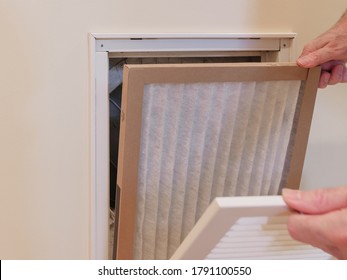 HVAC Service Technician Replacing Dirty Indoor Air Filter In Residential Heating And Air Conditioning System. Home Air Duct Ventilation System Maintenance For Clean Air. 