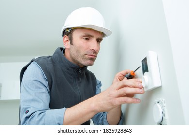 Hvac Technician Installing A Digital Thermostat