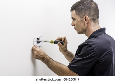 Hvac Technician Installing A Digital Thermostat