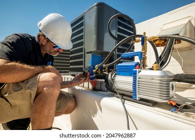 HVAC Technician Monitoring A Vacuum Gauge After An Air Conditioning Repair