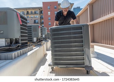 Hvac Technician Rolling A New Air Conditioner For An Install