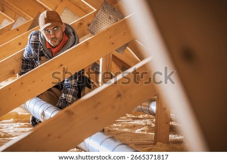 A HVAC worker examines insulation and ventilation pipes in an attic structure, ensuring proper installation and safety during the renovation process.