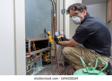 HVAC Worker Wearing Mask, Gloves And Safety Glasses, Checking Refrigerant Charge On A Heat Pump