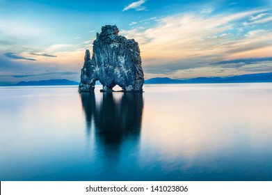 Hvitserkur is a spectacular rock in the sea on the Northern coast of Iceland. Legends say it is a petrified troll. On this photo Hvitserkur reflects in the sea water after the midnight sunset.