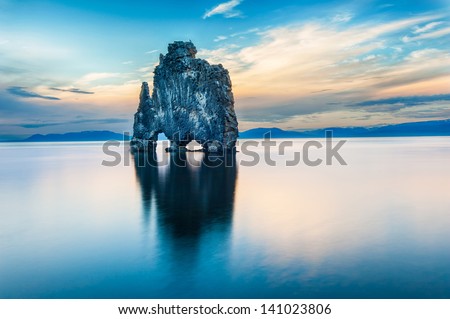 Hvitserkur is a spectacular rock in the sea on the Northern coast of Iceland. Legends say it is a petrified troll. On this photo Hvitserkur reflects in the sea water after the midnight sunset.