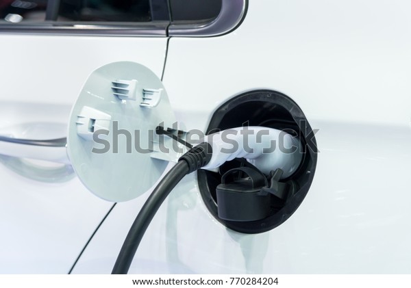 Hybrid electric car charging energy with the power cable\
supply plugged for clean power ecological way of driving to safe\
environment 