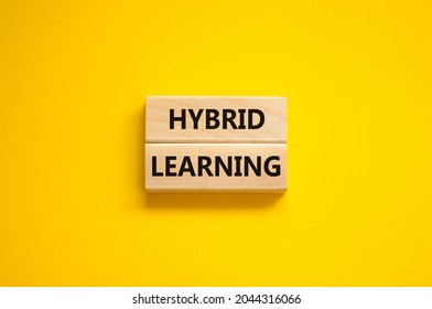 Hybrid learning symbol. Concept words 'Hybrid learning' on wooden blocks on a beautiful yellow background. Business, educational and hybrid learning concept, copy space.