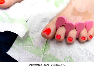 Hybrid Nails Painted Red At The Feet, Separated By A Pink Spacer.