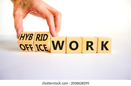Hybrid or office work symbol. Businessman turns cubes and changes words 'office work' to 'hybrid work'. Beautiful white background. Business, hybrid or office working concept, copy space.