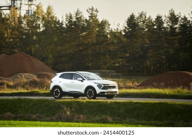 A hybrid SUV car journeys along a scenic road with majestic nature and a golden sunset in the backdrop. - Powered by Shutterstock