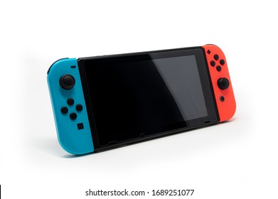 Hybrid video game console with switch detachable controllers on both sides. The left gamepad is blue and the right one red. Touchscreen with protective film of tempered glass. - Shutterstock ID 1689251077