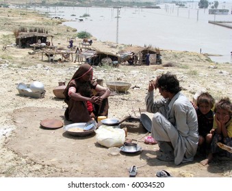 HYDERABAD, PAKISTAN - AUG 27: Flood-affected people prepare food at a relief camp on August 27, 2010 Hyderabad.