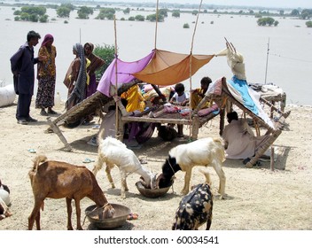 HYDERABAD, PAKISTAN - AUG 27: A flood-affected family from Jaffarabad live out in the open while waiting for relief goods on August 27, 2010 in Hyderabad.