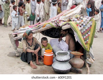 HYDERABAD, PAKISTAN - AUG 30: A flood-affected family lives under a makeshift canopy at a relief camp on August 30, 2010 in Hyderabad.