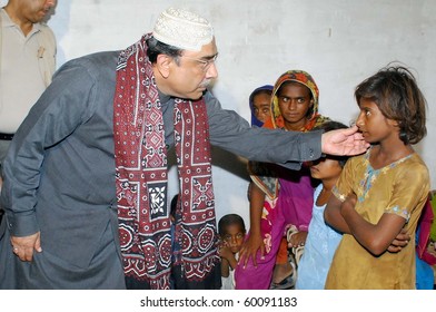 HYDERABAD, PAKISTAN - AUG 30: Pakistan President Asif Ali Zardari Consoles A Flood-affected Girl During A Relief Camp Visit At Kohsar On August 30, 2010 In Hyderabad.