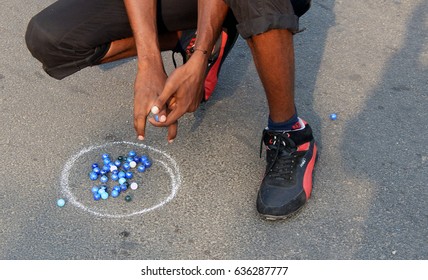 HYDERABAD,INDIA-MAY 7: Indian People Play Marbles On The Road Outdoors On Physical Literacy Days Sunday Mornings On Open Roads May 7,2017 In Hyderabad                               