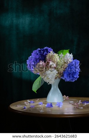 hydrangea flowers in ceramic vase on wooden background