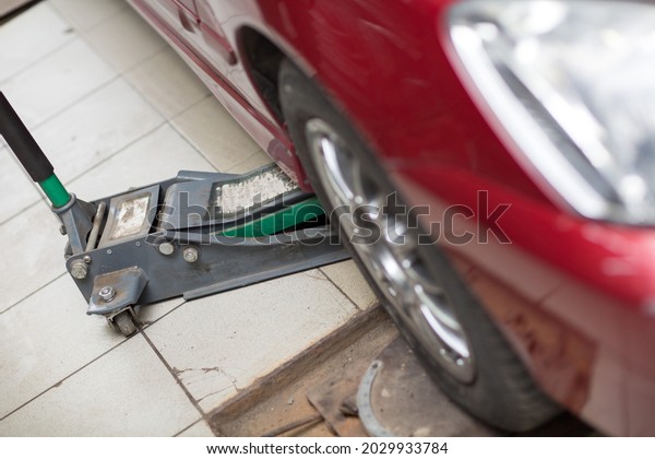 Hydraulic car jack\
to lift car in auto\
repair.