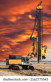Hydraulic drilling machine at the construction site makes piles. Pile field. Modern drilling rig. Piles against the sunset. Work drilling rig in difficult conditions