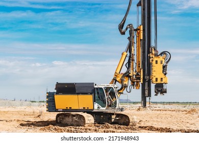 Hydraulic drilling machine at the construction site. Pile field. Modern drilling rig. The device of piles on the background of the blue sky. Work drilling rig when driving bored piles - Shutterstock ID 2171948943