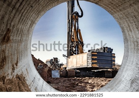 Hydraulic drilling machine in excavation at the construction site. Modern drilling rig. The device of piles on the background of the blue sky. Work drilling rig when driving bored piles