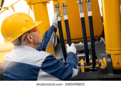 Hydraulic engineer doing safety check on new installation hoses of modern drilling industrial machine - Powered by Shutterstock