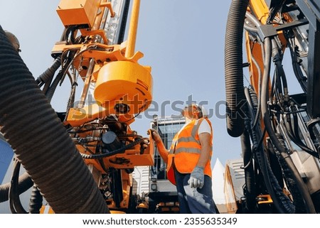 Hydraulic engineer doing safety check on new installation hoses of modern drilling industrial machine. Concept industry work.