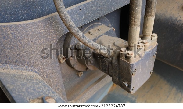 Hydraulic motor and oil\
pipes. Roller stator with dirty pipes in compactor hydraulics that\
converts hydraulic energy into mechanical energy with copy space.\
Selective focus