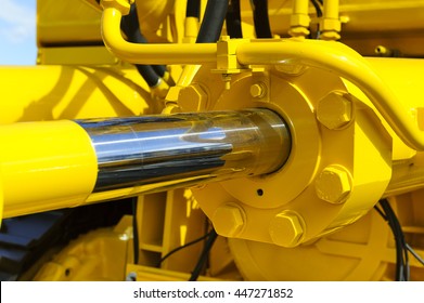 Hydraulic piston system for bulldozers, tractors, excavators, chrome plated cylinder shaft of yellow machine, construction heavy industry detail, selective focus 