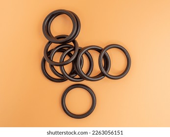 Hydraulic and pneumatic o-rings in black in different sizes on an orange background. Rubber gaskets for plumbing. copy space. - Powered by Shutterstock