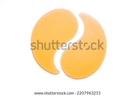 Hydrogel golden yellow eye patches isolated on white background. Cosmetic moisturizing under eye patches or pads with gold and collagen.