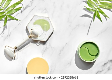 Hydrogel Pads And Chinese Stone Roller On Off White Marble Stone Background, Palm Leaf. Direct Sunlight, Long Shadows. Eye Patch, Skincare Beauty Treatment At Home. Part Of Skin Daily Care Routine.