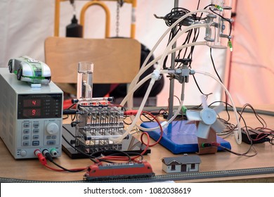 Hydrogen Fuel Cells Experiment. Hydrogen (H2) Cells Powering Model Train Locomotive, Light Diodes And Air Ventilator. New Technology Concept.