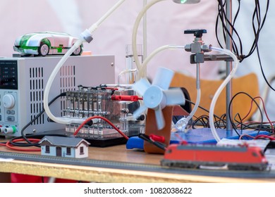 Hydrogen Fuel Cells Experiment. Hydrogen (H2) Cells Powering Model Train Locomotive, Light Diodes And Air Ventilator. New Technology Concept.