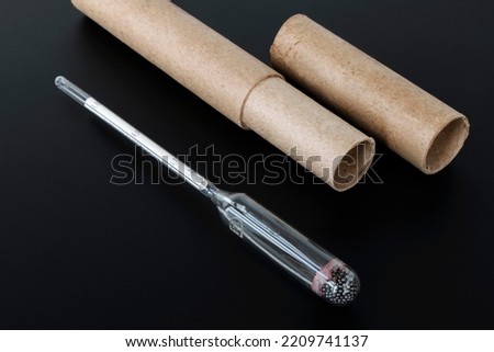 hydrometer, a tool for measuring the density of the battery electrolyte, on a black background