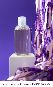 Hydrophilic Cleanser Oil Mockup And Holiday Tinsel On Cube Podium On Violet Background, Vertical