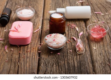 hygiene, beauty products, pink soap, cream, bath salt, tincture, old wooden table background - Shutterstock ID 1303607932