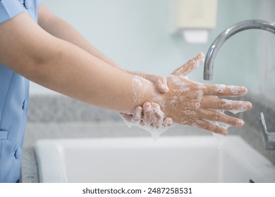 Hygiene and cleaning hands.Washing hands rubbing with soap for corona virus prevention, hygiene to stop spreading coronavirus.Close up woman hand washing in the kitchen. - Powered by Shutterstock