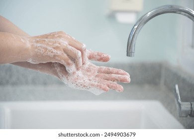 Hygiene and cleaning hands.Washing hands rubbing with soap for corona virus prevention, hygiene to stop spreading coronavirus.Close up woman hand washing in the kitchen. - Powered by Shutterstock