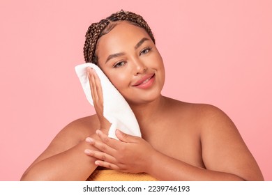 Hygiene concept. Beautiful black plus size woman drying clean face with towel, standing over pink studio background. Morning beauty routine - Powered by Shutterstock