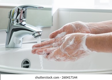 Hygiene concept. Washing hands with soap under the faucet with water - Shutterstock ID 260417144
