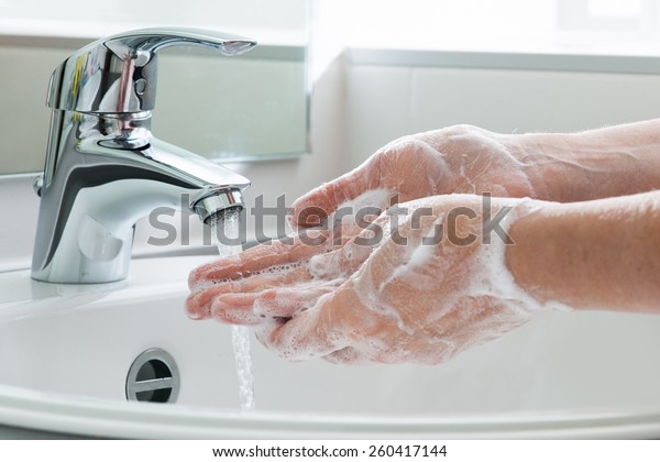 Hygiene concept. Washing hands with soap under the\
faucet with water