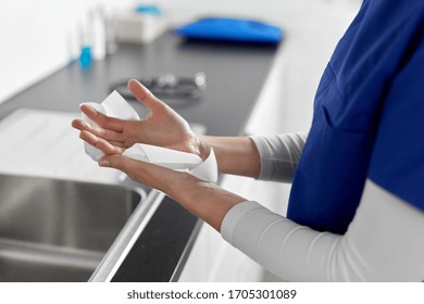 Hygiene, Health Care And Safety Concept - Close Up Of Female Doctor Or Nurse Drying Hands With Paper Tissue At Hospital