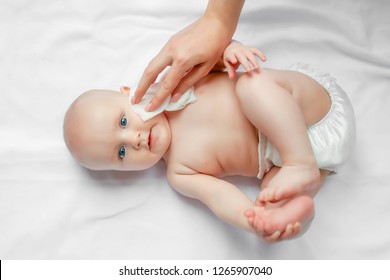 Hygiene - young mom wiping the baby skin body and face with wet wipes carefully on white background. concept cleaning wipe, pure, clean.