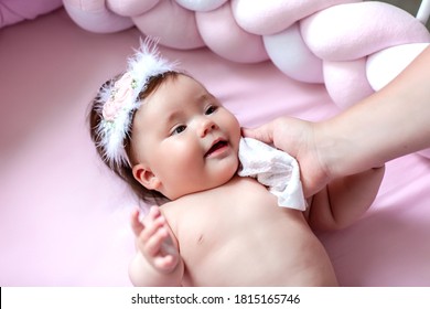 Hygiene - Young Mom Wiping The Baby Skin Body And Face With Wet Wipes Carefully On Pink Background. Concept Cleaning Wipe, Pure, Clean.