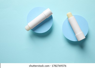 Hygienic lipsticks on turquoise background, flat lay